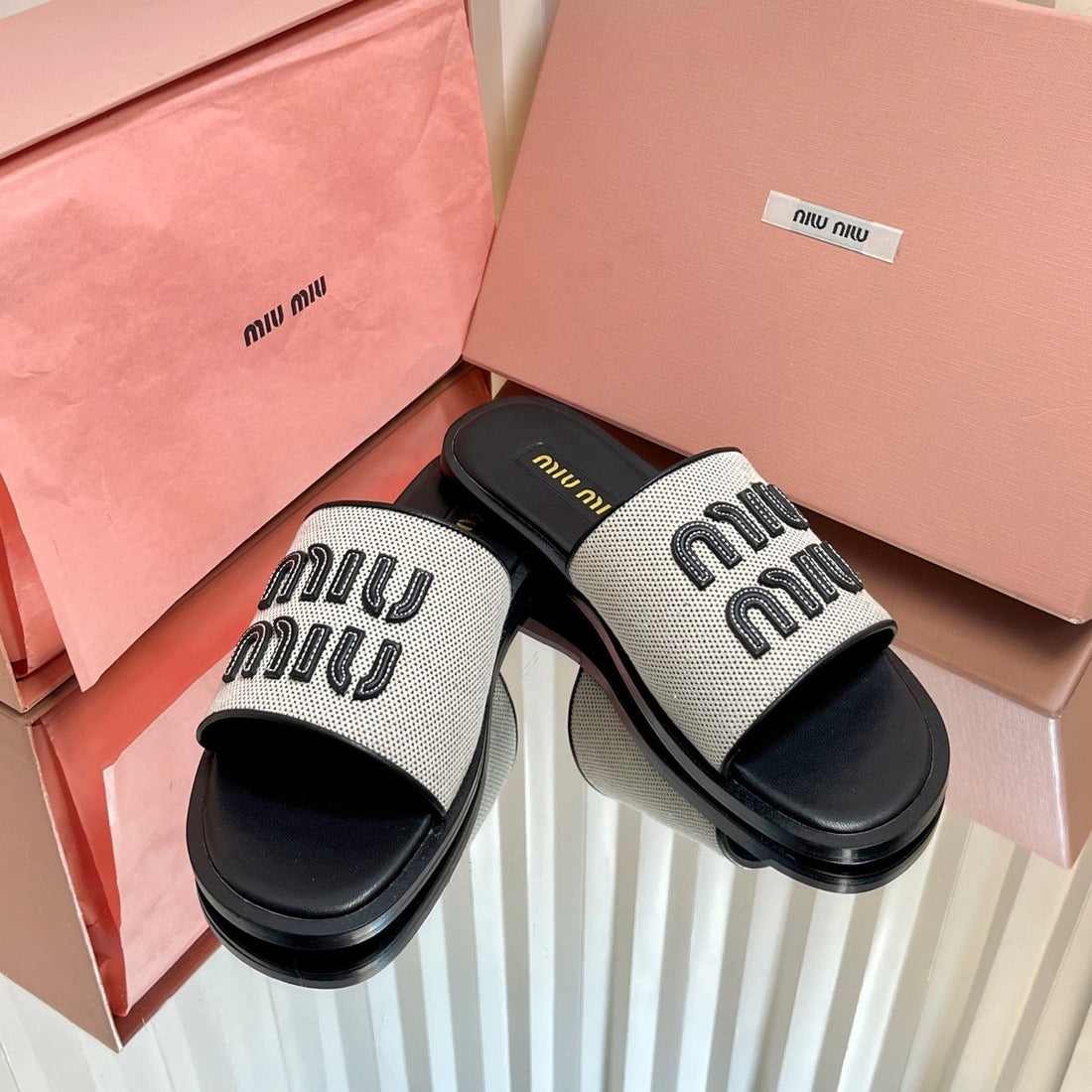 SLIDES SANDALS IN BLACK CALFSKIN AND WHITE STRAW WOVEN